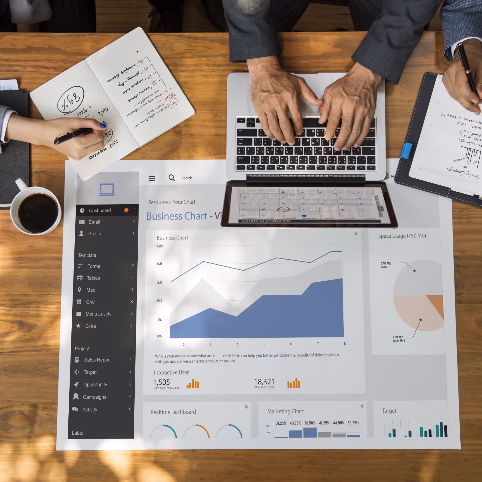 Business meeting with two people analyzing charts and notes around a laptop on a wooden table.