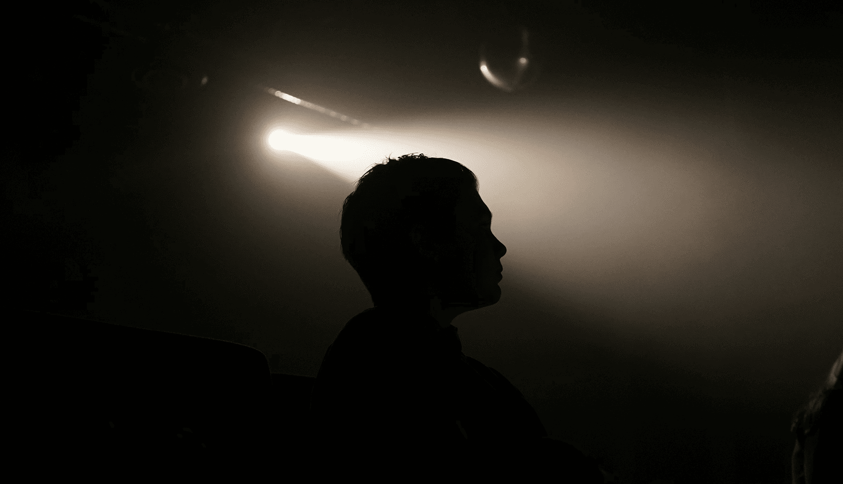 Silhouette d’un homme photographié en contre-jour, éclairé par une lumière placée derrière lui.