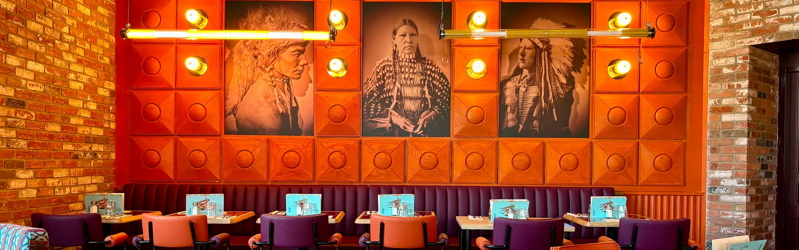 Décoration intérieure d’un restaurant Indiana Café avec portraits de chefs amérindiens, banquettes colorées et ambiance chaleureuse