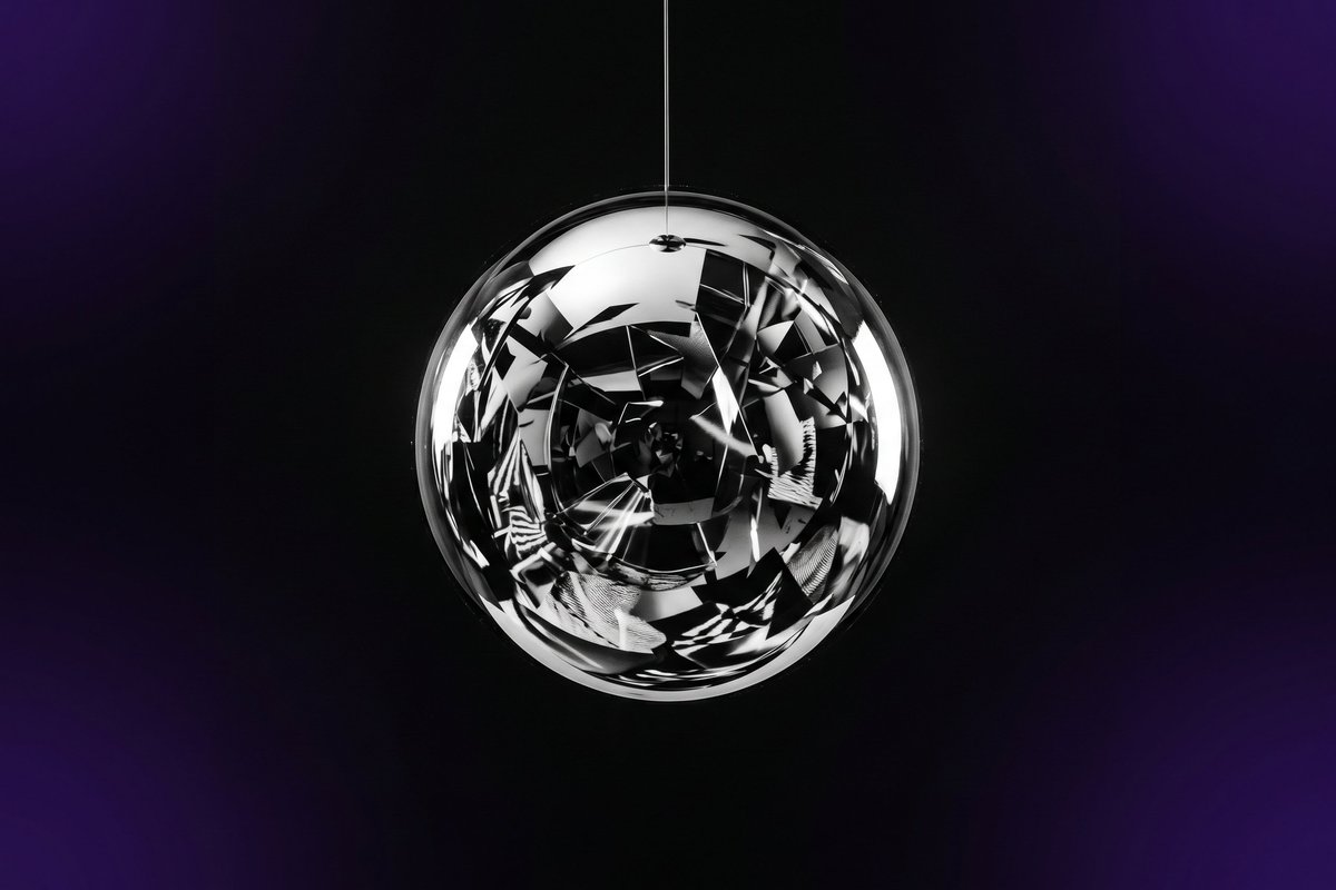 Polished mirror sphere reflecting fragmented light, symbolising brand reputation shaped by external perception