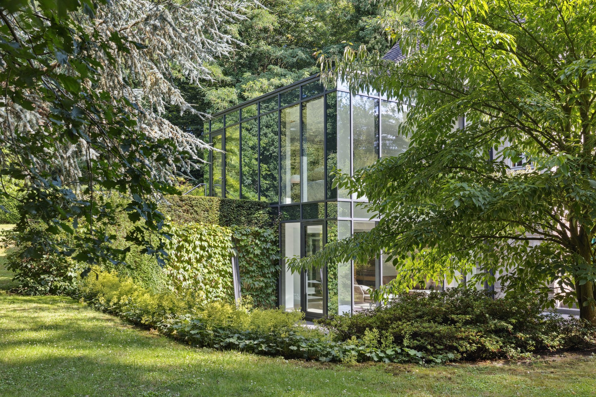 Glassfront eines Hauses in einem grünen Garten