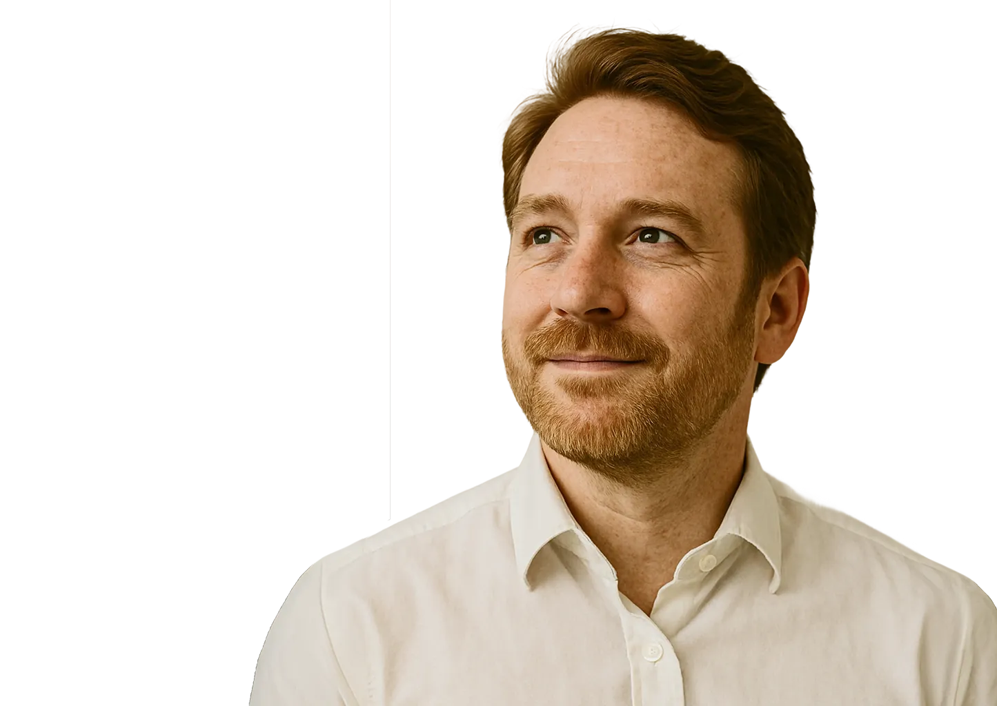 Man with red hair smiling and looking to the side in a white shirt.