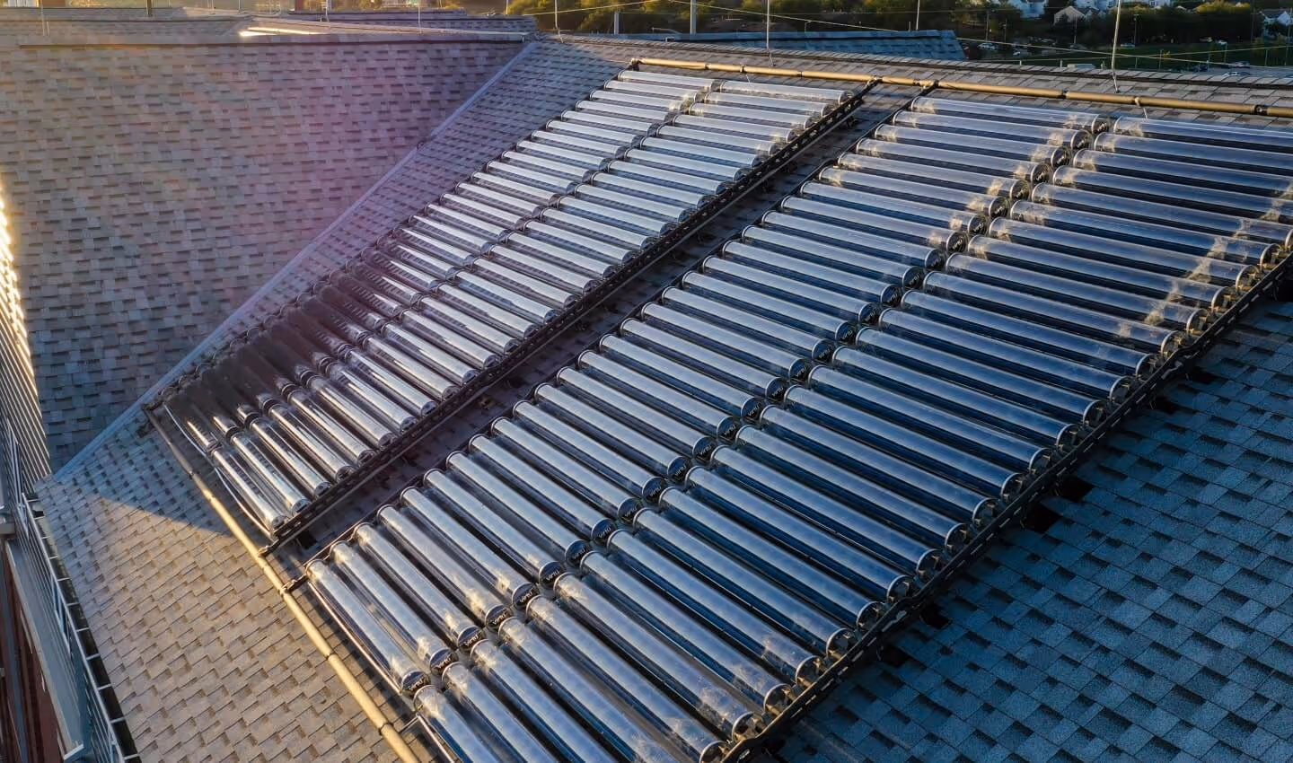 Solar thermal collectors on residential building pitched roof.