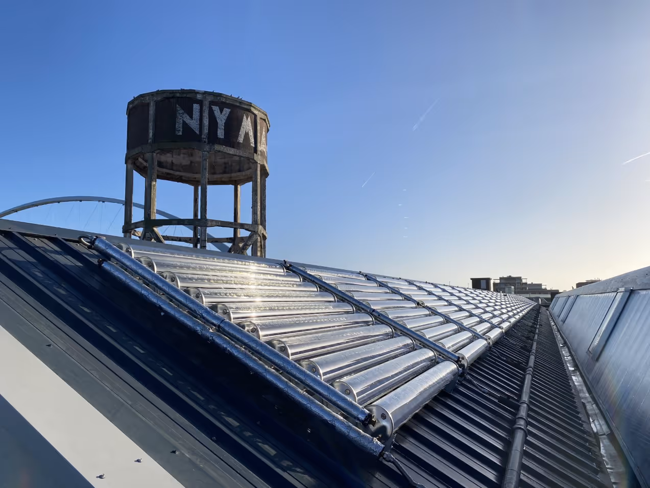 Rows of solar thermal collectors on industrial roof.