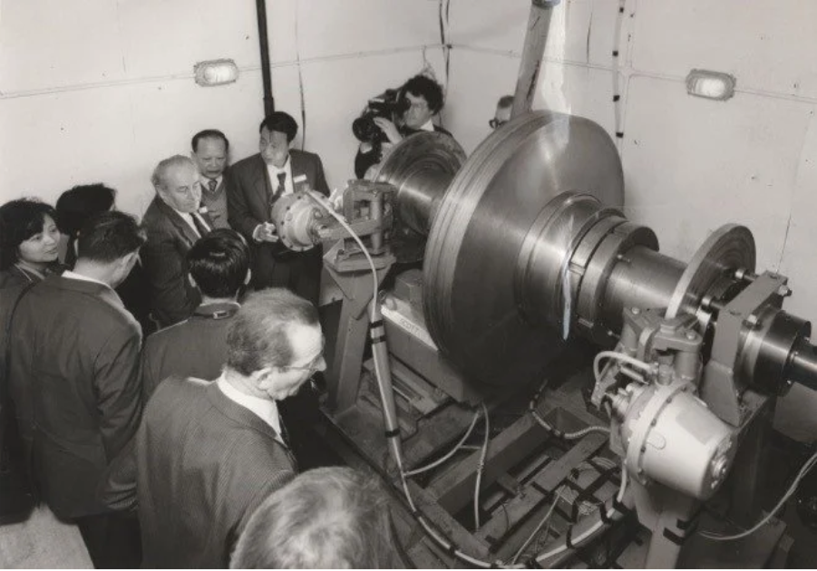 A group of men looking at a machineAI-generated content may be incorrect.