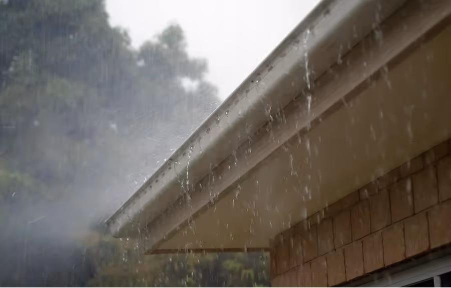 Rain falling down on a roof and off the gutter