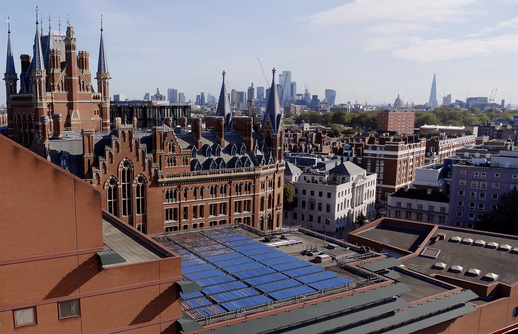 Ariel view of British Library with solar thermal collectors on roof and London skyline in background