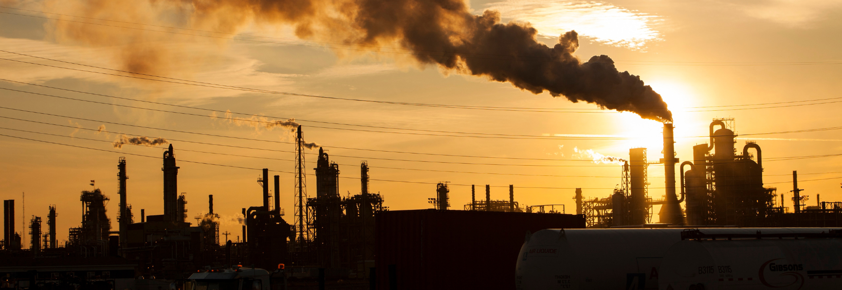 Gas plant with thick smoke and sunset