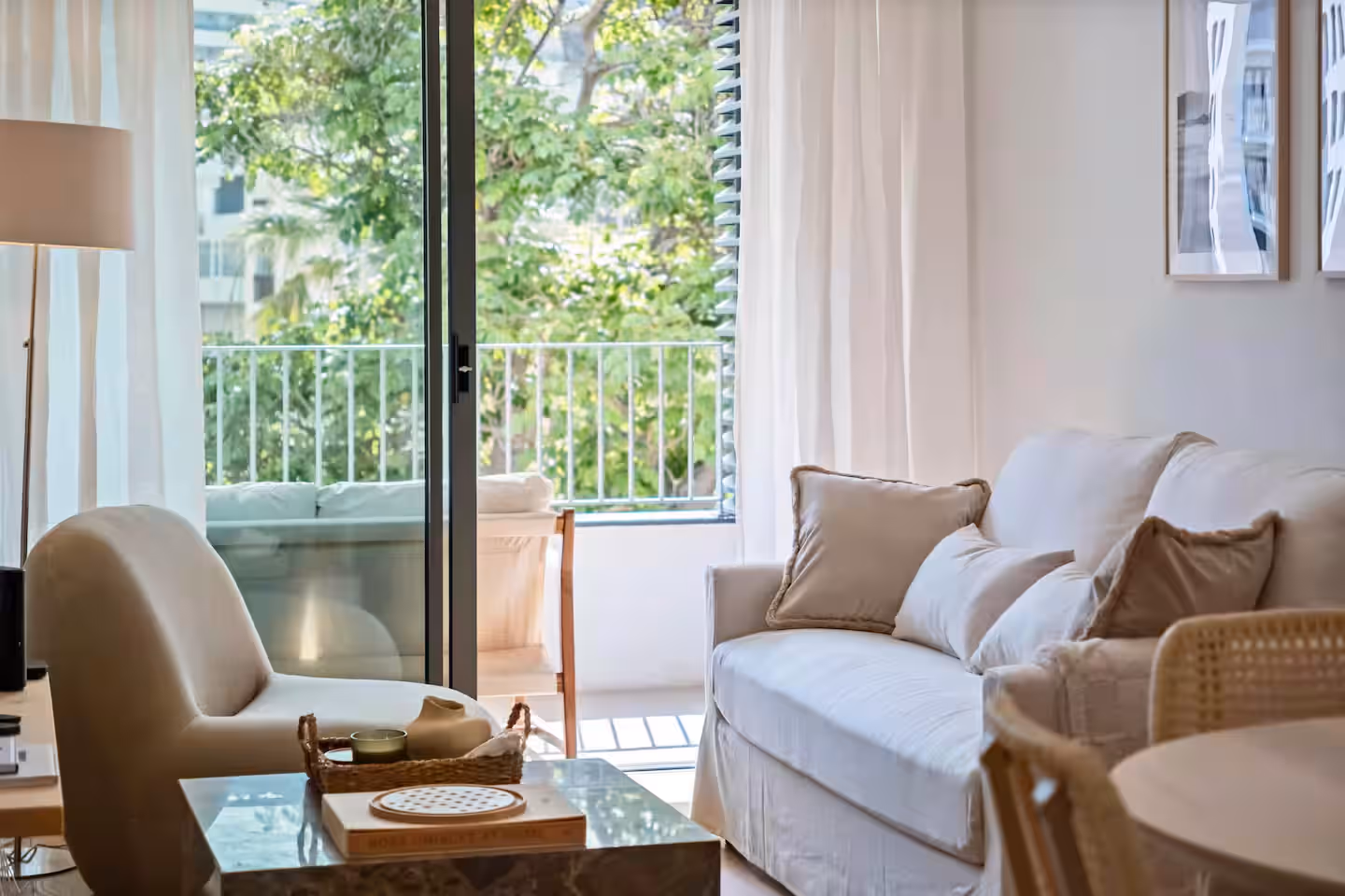 Bright living room with neutral tones, soft lighting, and balcony access, reflecting the calm style of Island Escape in Madeira.