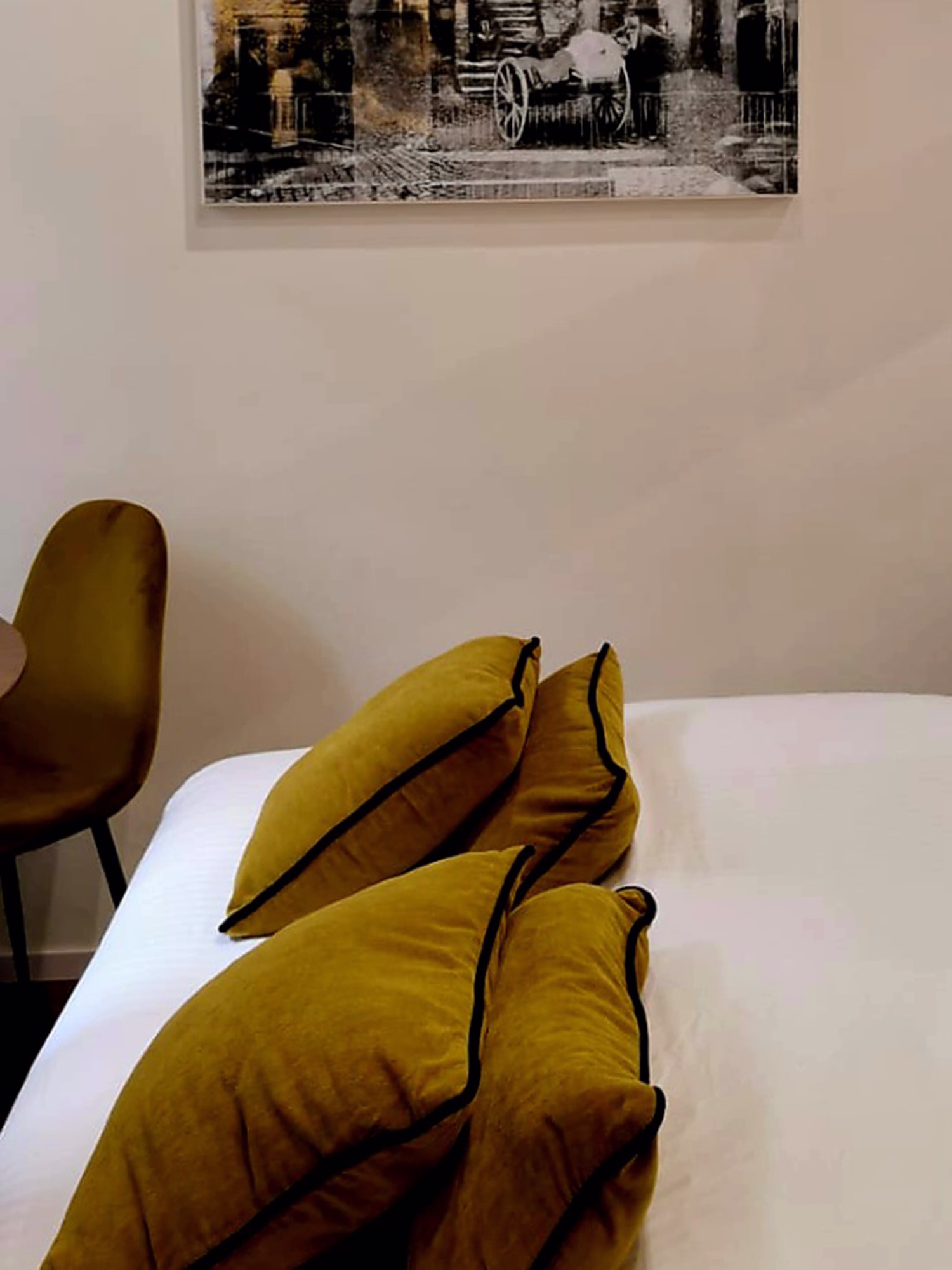 A modern kitchen with white cabinets, a large island with bar stools, and two pendant lights