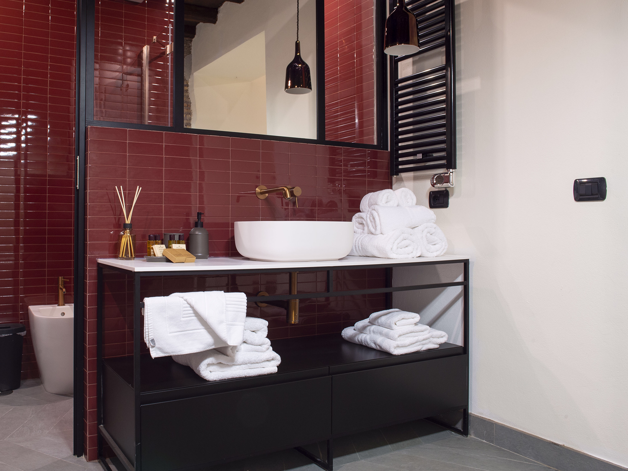 A modern bedroom with a white bed, wooden headboard, black lamp on a side table, and high windows