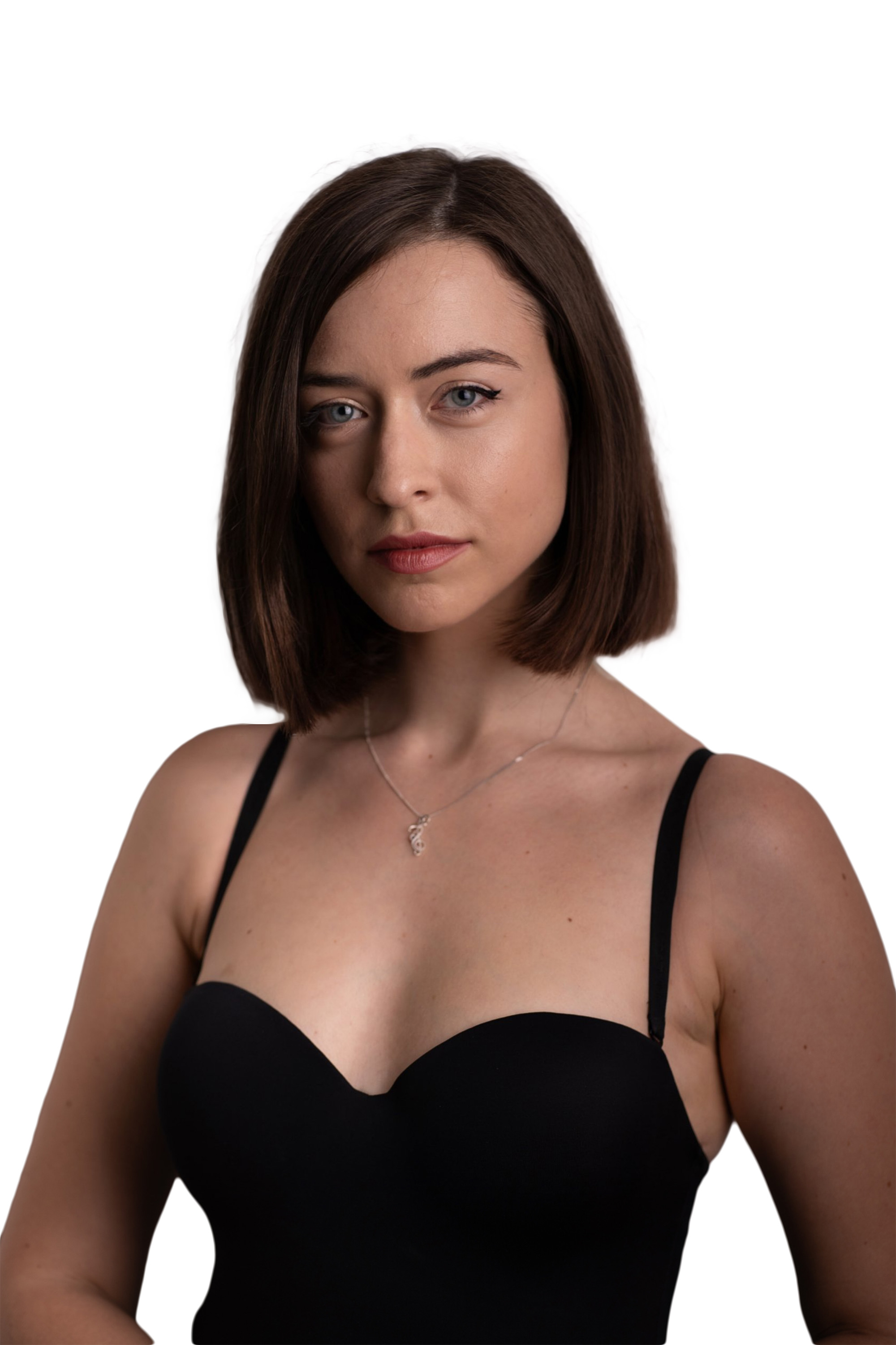 Porträt einer jungen Frau mit schulterlangen braunen Haaren, die ein schwarzes trägerloses Oberteil und eine silberne Halskette trägt.