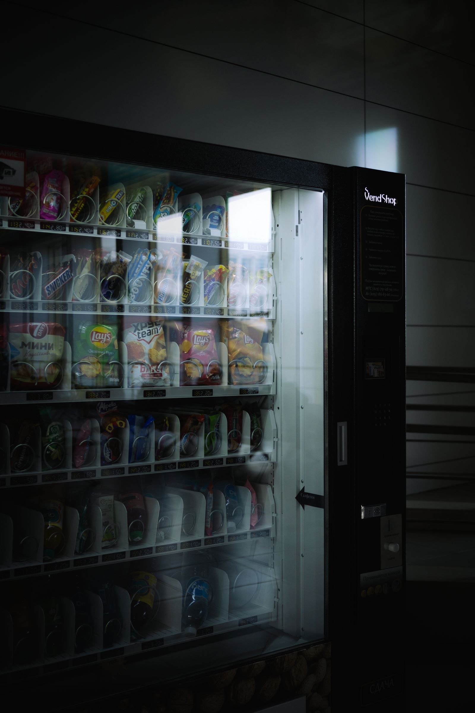 Interior iluminado de una máquina expendedora con varios niveles de producto
