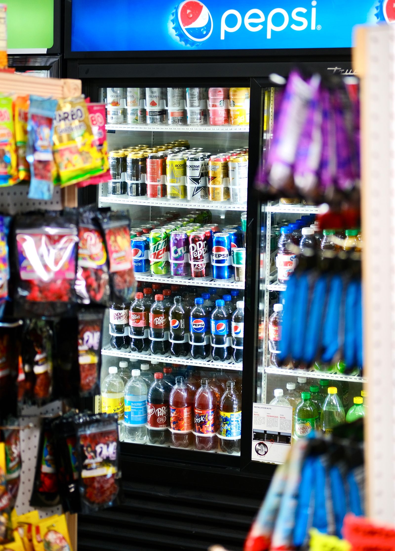 Anaquel refrigerado y estantes de botanas en un espacio de autoservicio