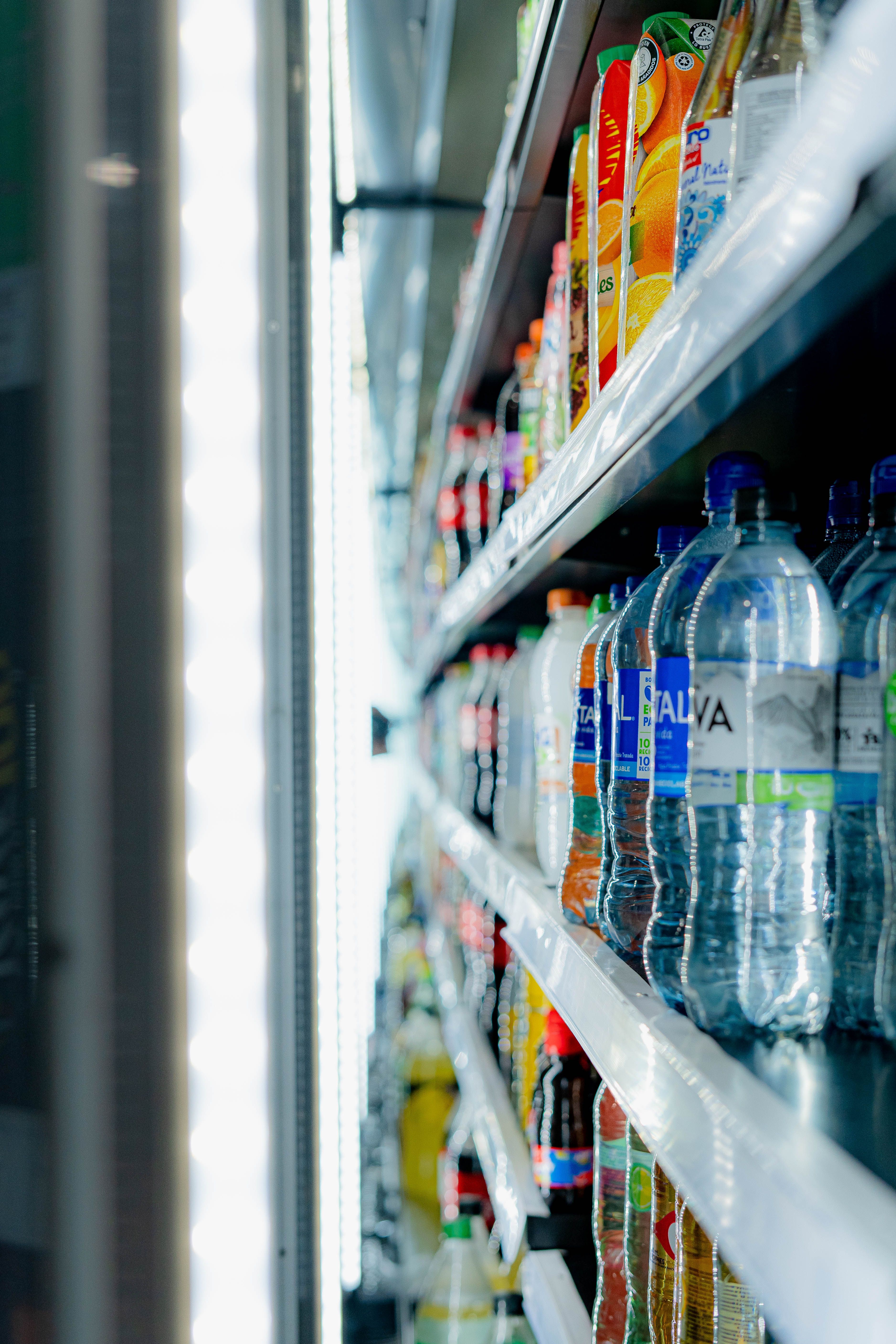 Refrigerador vertical con bebidas y jugos en un espacio de autoservicio