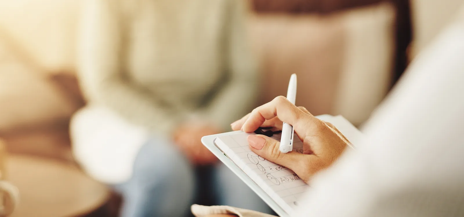 Jeune adulte en entretien avec une psychologue dans un bureau lumineux, première étape d'une évaluation du TDAH