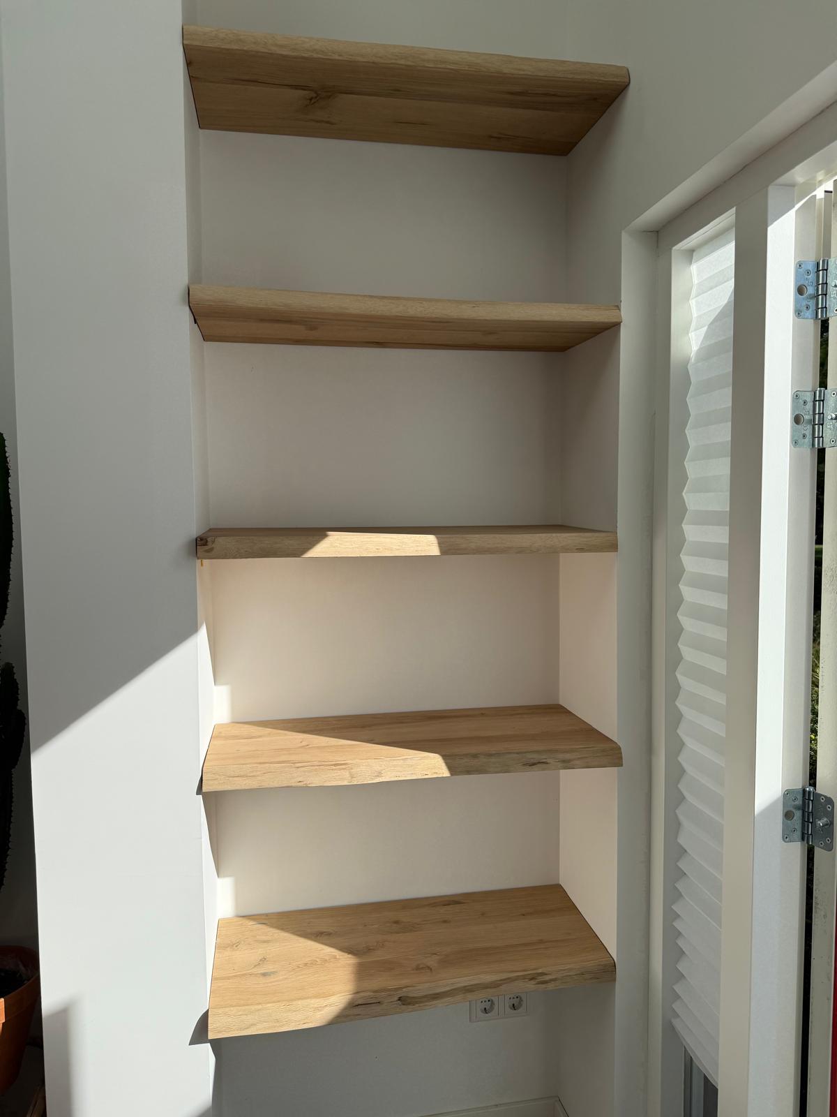 Op maat gemaakte planken in licht hout, geplaatst in muurnis