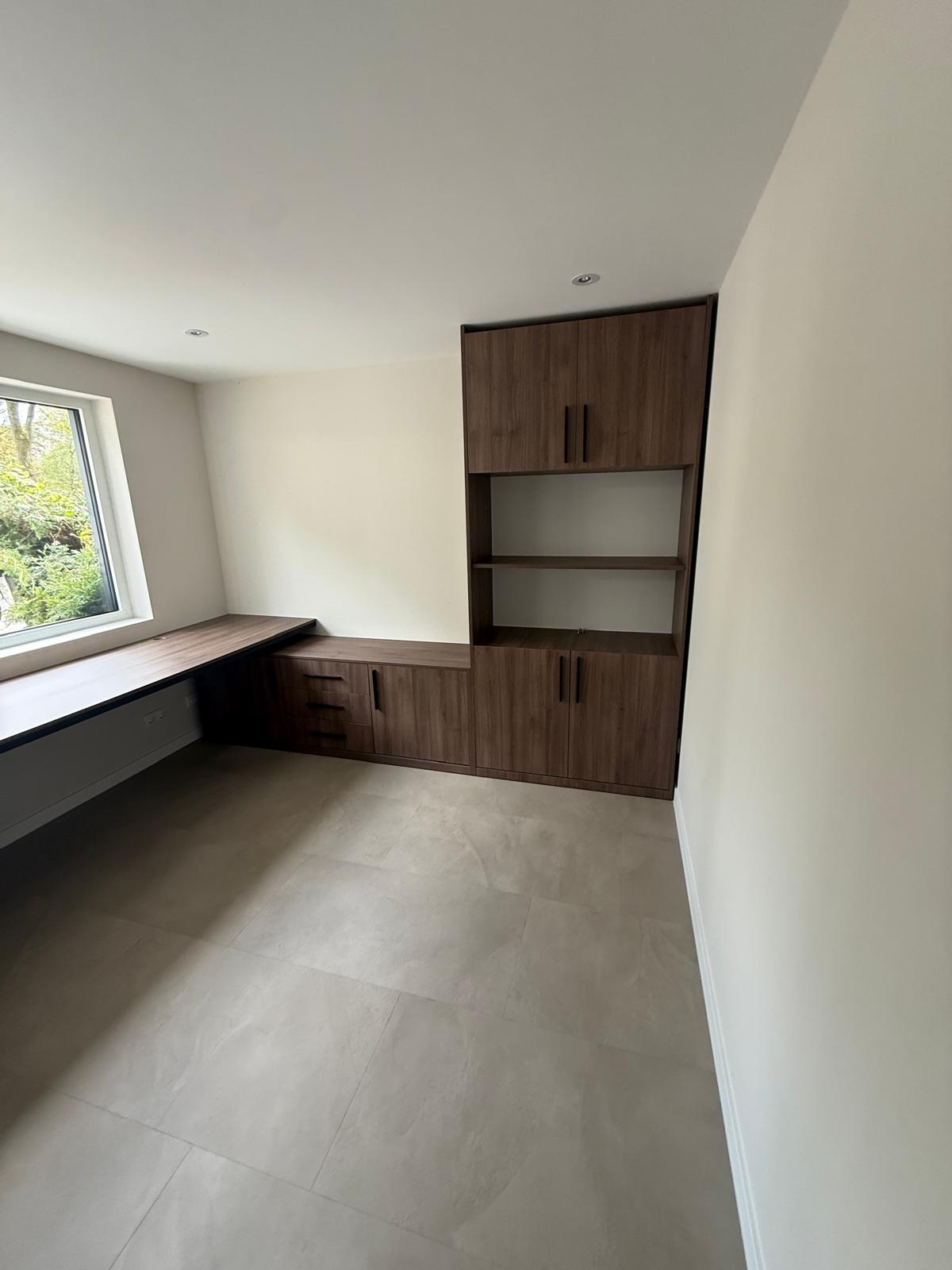 Een houten ingebouwde kast met bureaublad.