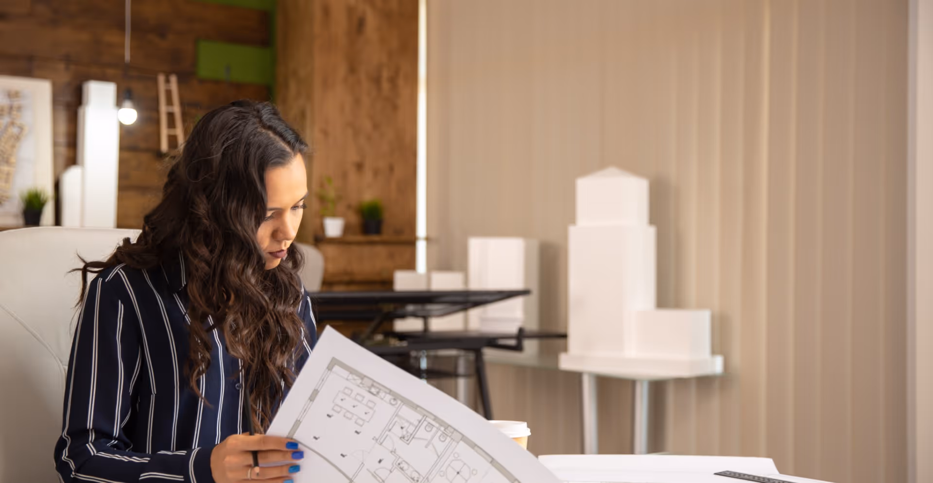Designer reviewing architectural blueprints in a modern office workspace