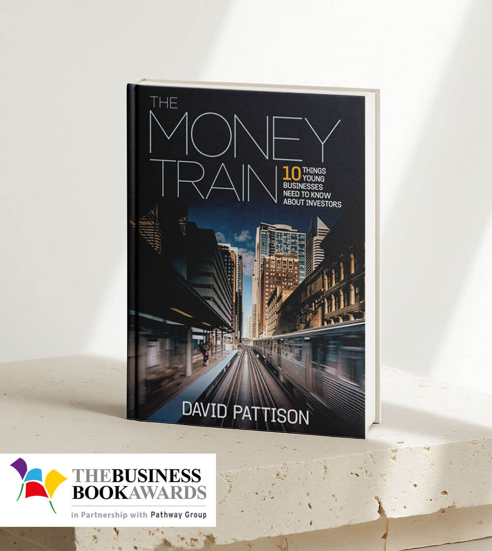Book titled 'The Money Train' by David Pattison with a city train station cover image, displayed on a stone surface alongside The Business Book Awards logo.