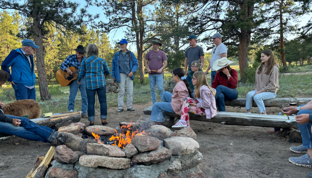 Ranch guests enjoying cowboy singing around the campfire