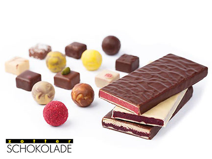 Assorted handmade chocolates including chocolate bars and truffles with various coatings and toppings.