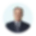 Blurred portrait of a person in formal attire against a light background.