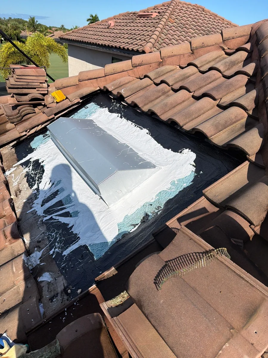 Replacement roof vent during repair with white Polyglass PolyFlash 1C liquid flashing visible around the flange