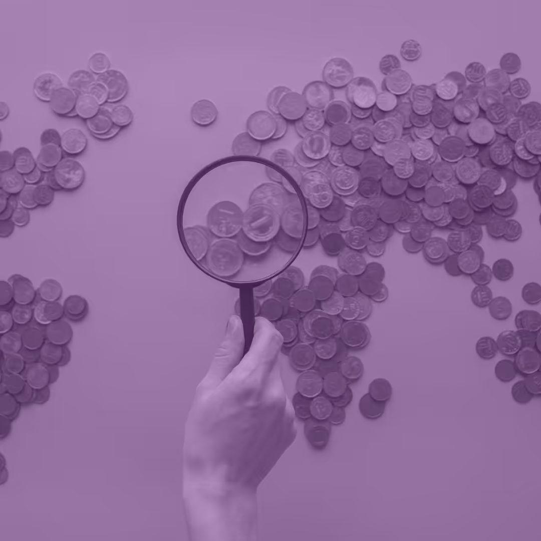 A map of the world made up of coins with a magnifying glass zooming in on the UK.