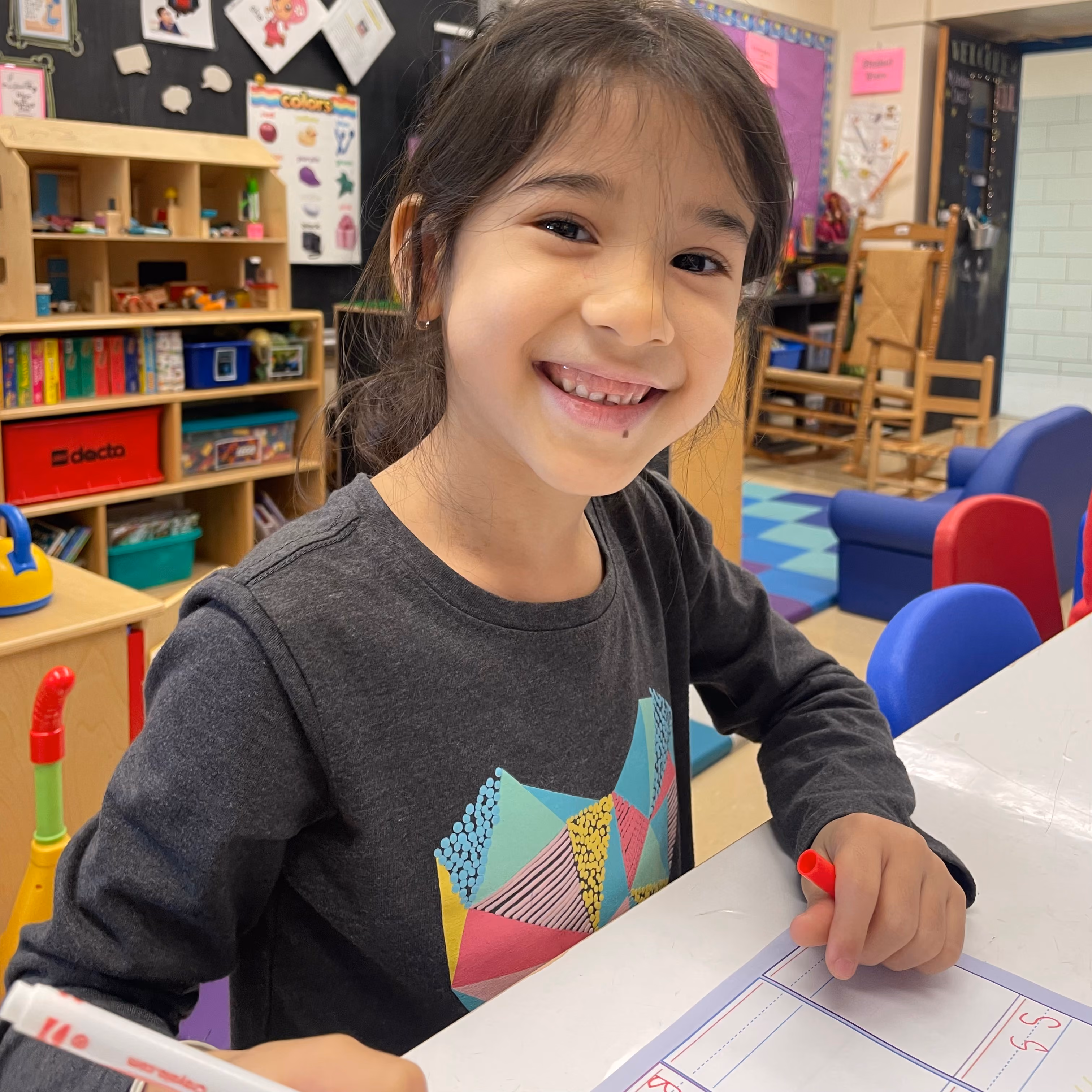 Student smiling while working at classroom table