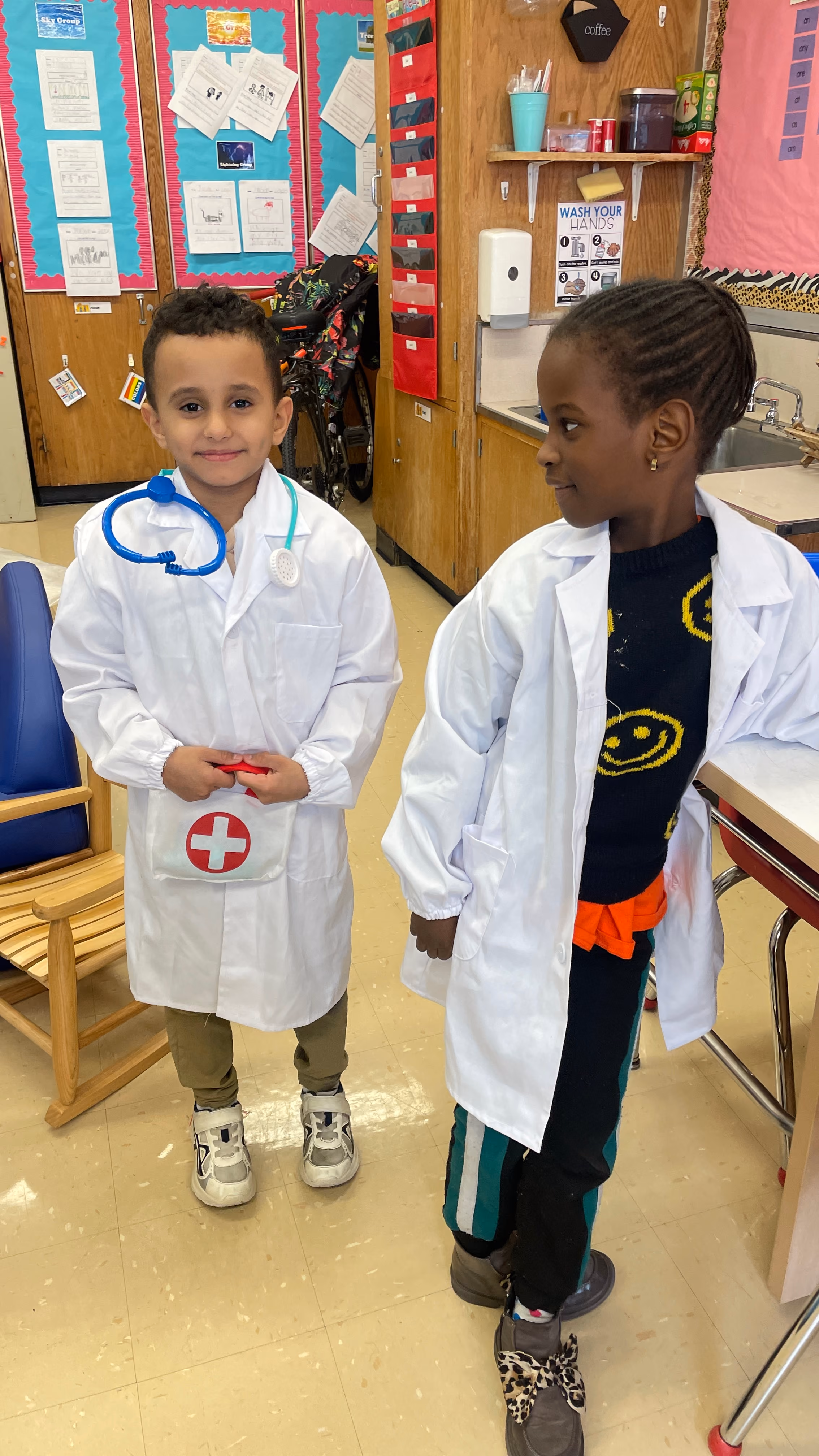 Two students dressed as doctors in white lab coats