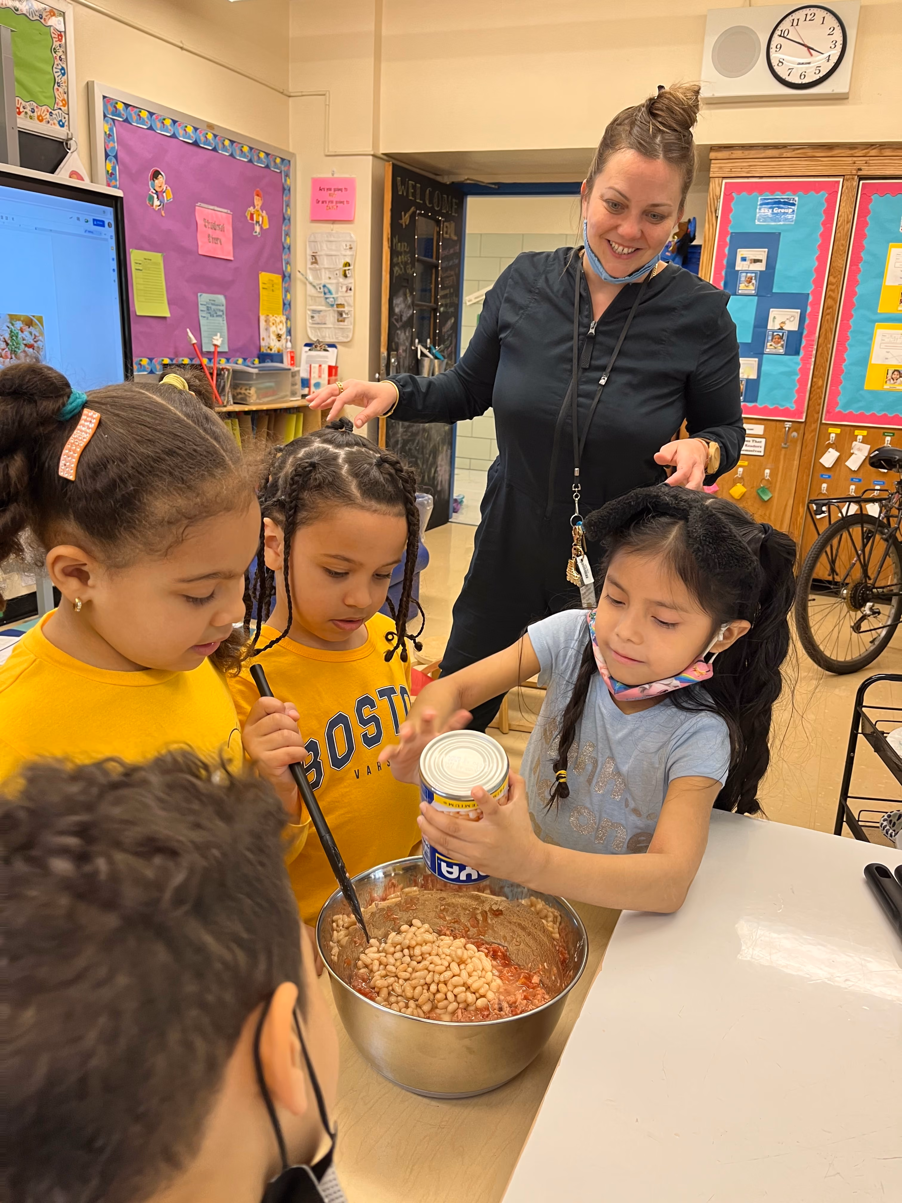 Students and teacher preparing food in classroom kitchen