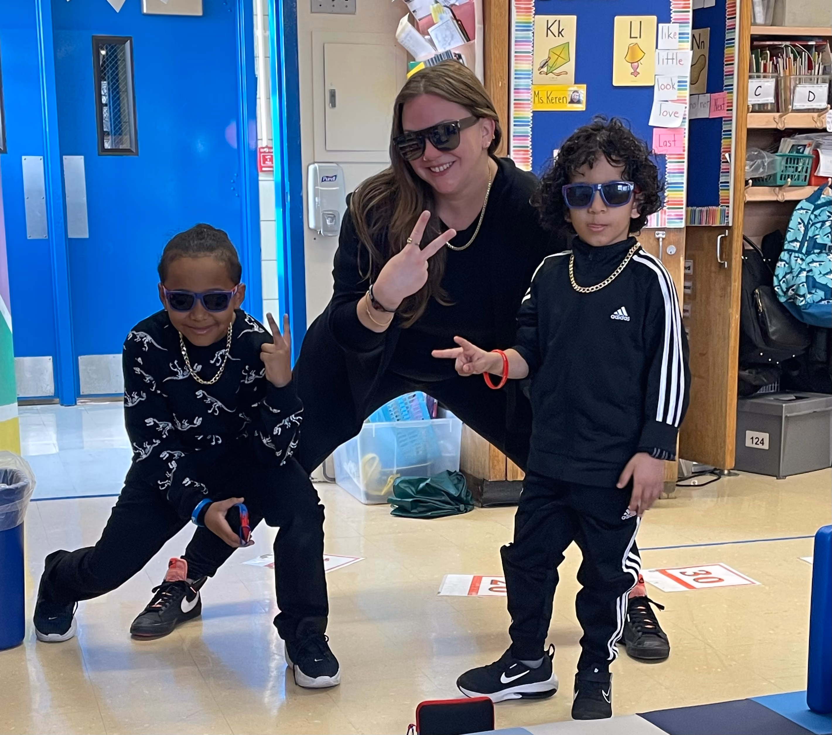 Teacher and two students posing in sunglasses in classroom