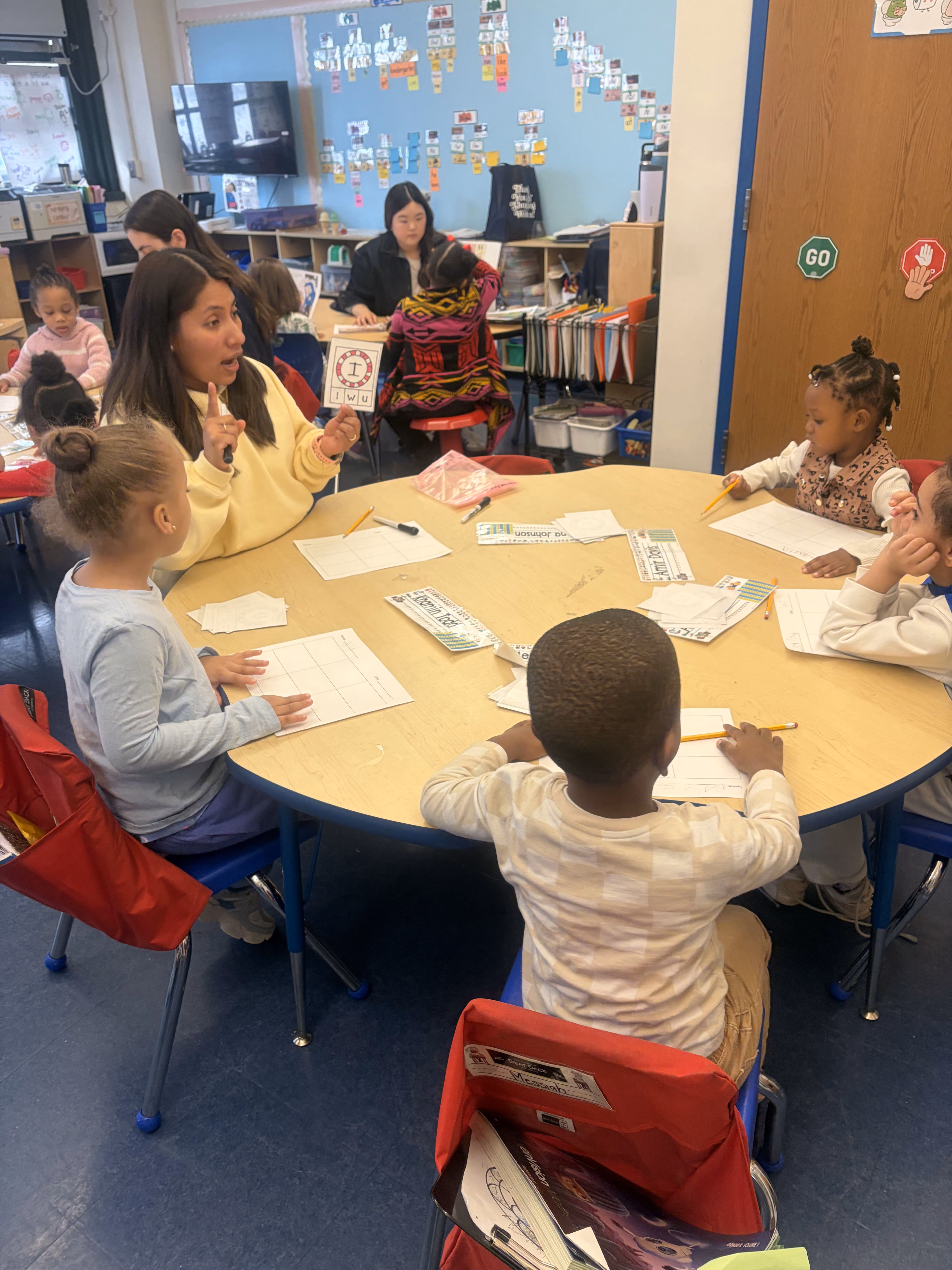 Teacher leading small group lesson with elementary students at table