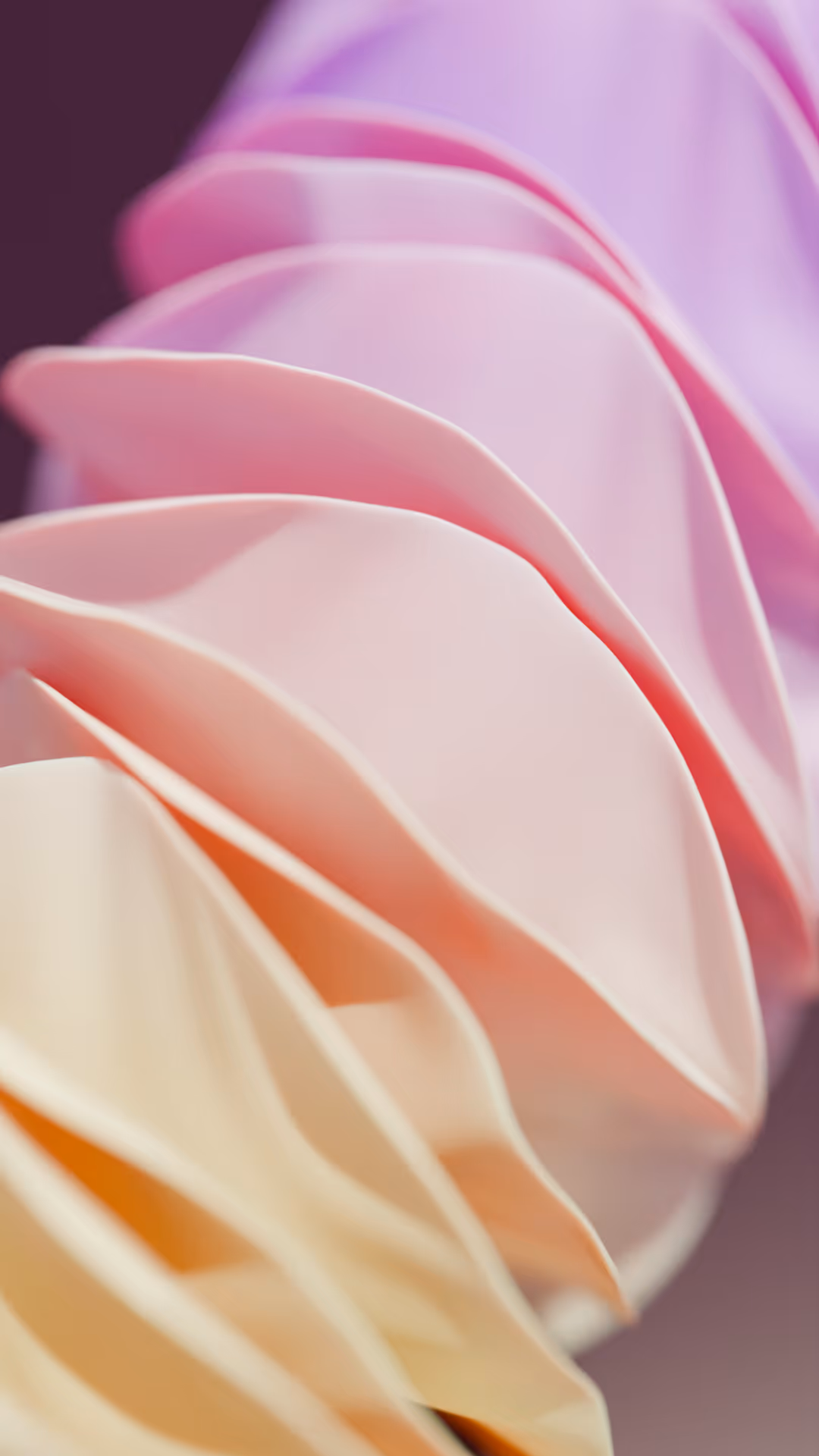 Abstract close-up of layered, softly curved shapes in pastel colors of cream, pink, and lavender with a blurred dark background.