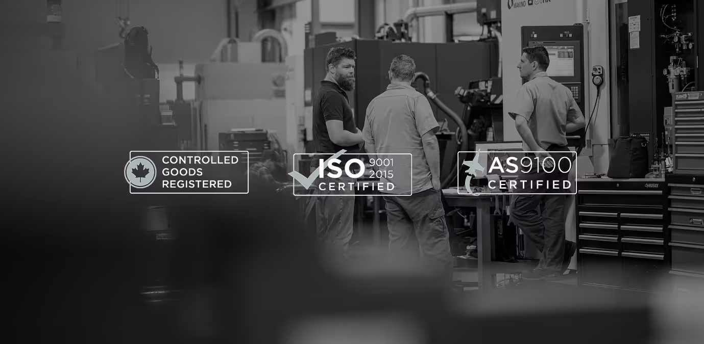 Three men standing and talking in an industrial workshop surrounded by machinery with overlays showing certifications: Controlled Goods Registered, ISO 9001 2015 Certified, AS 9100 Certified.