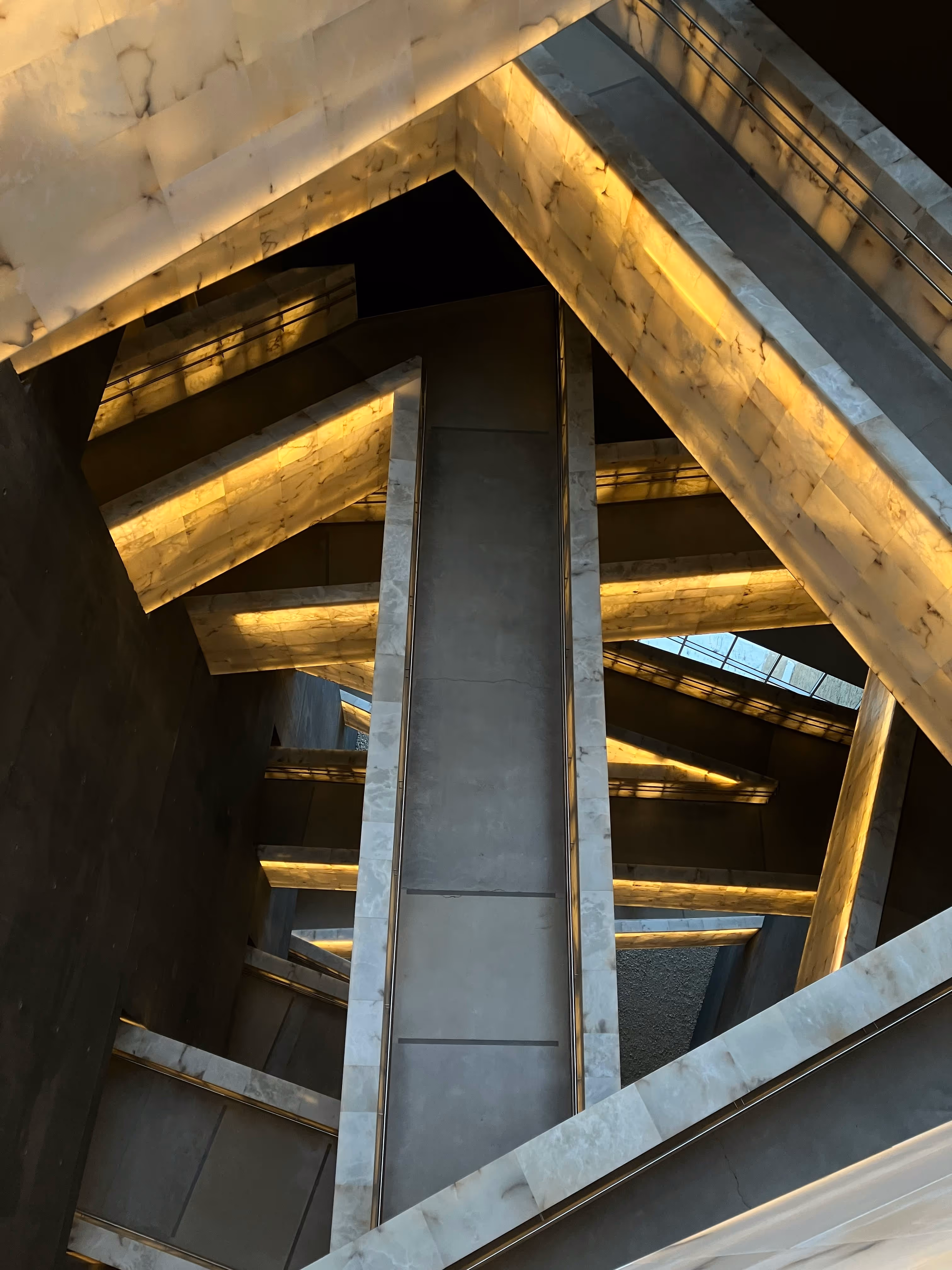 Intersecting concrete beams with warm lighting and geometric design.