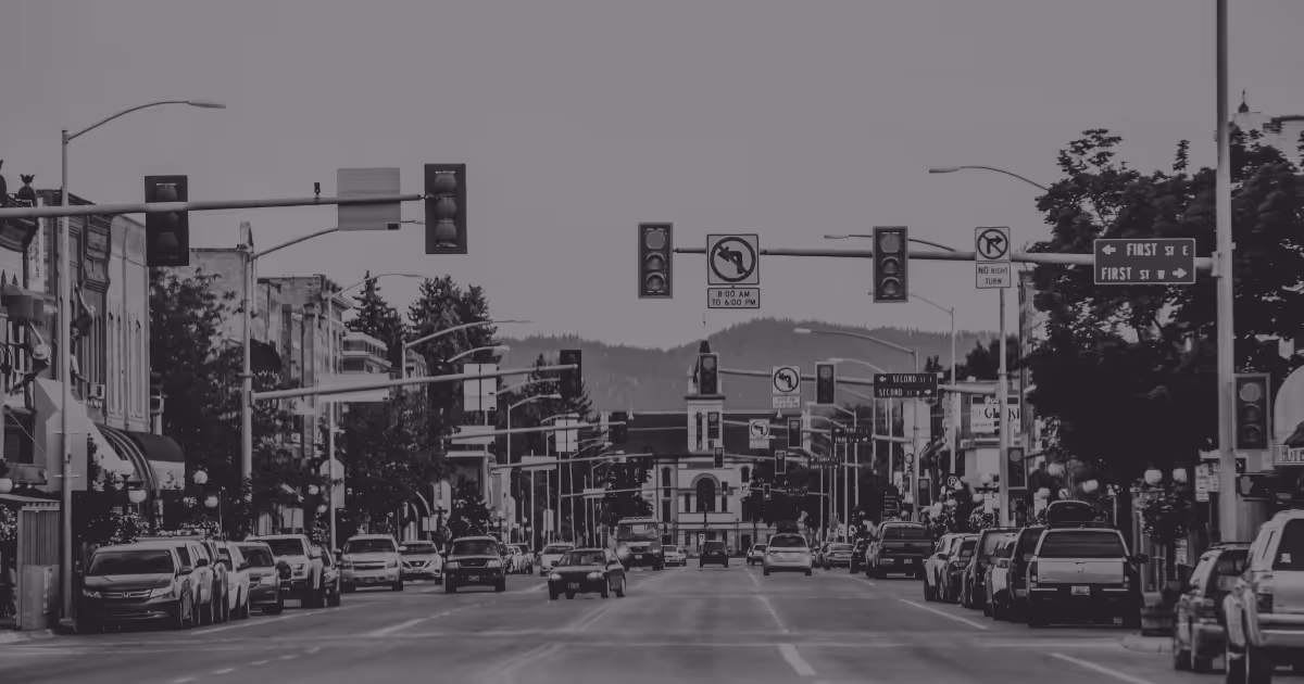 Montana street view of cars lined up and driving through an urban intersection with traffic lights.