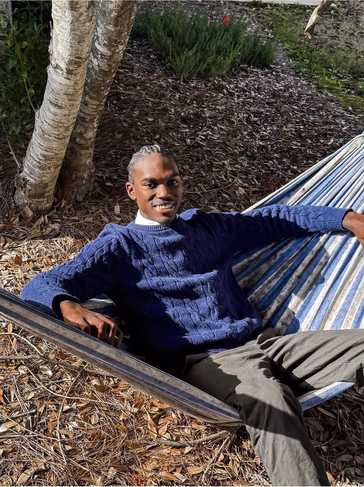 Person relaxing in a hammock in a wooded outdoor area