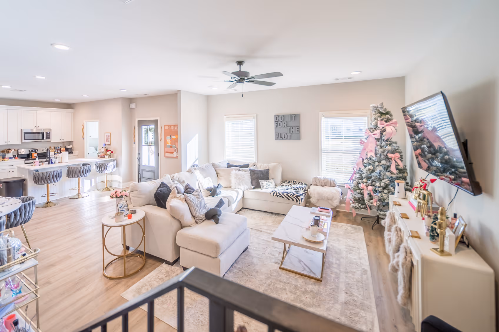 Furnished living area with tv, sofa, christmas tree and view into kitchen