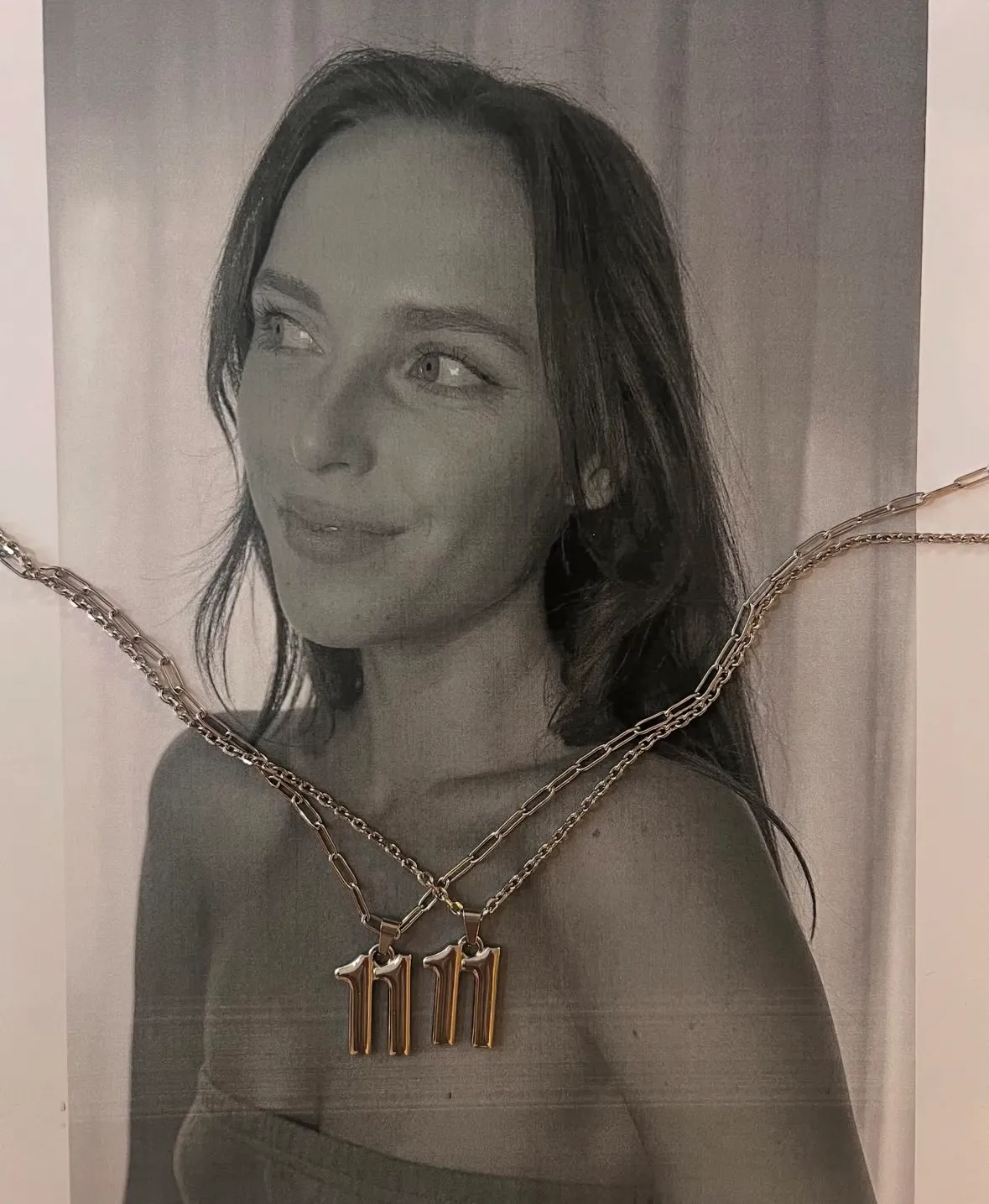 A pair of custom gold 11:11 necklaces 