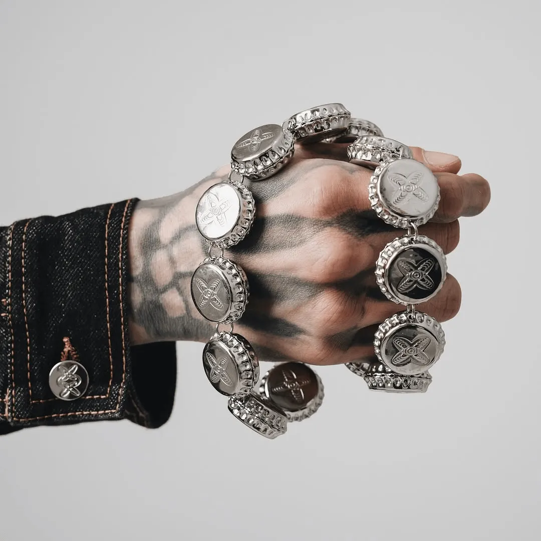 A hand holding the bottle cap wallet chain