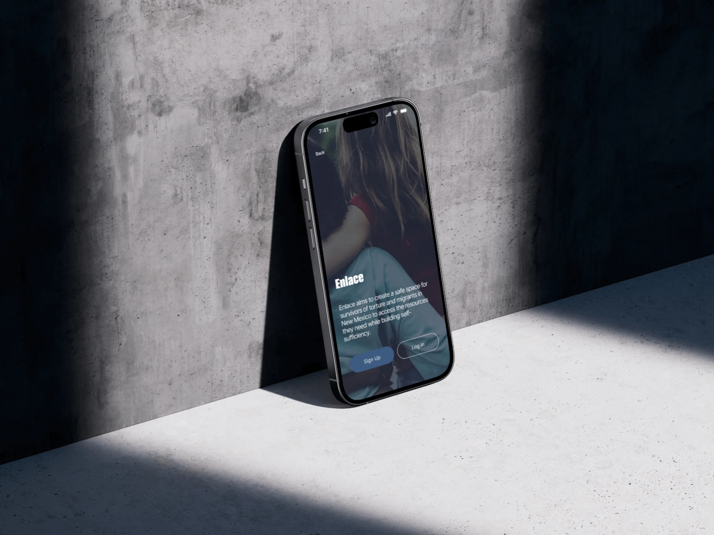 Enlace high fidelity prototype on a phone leaning against a concrete wall