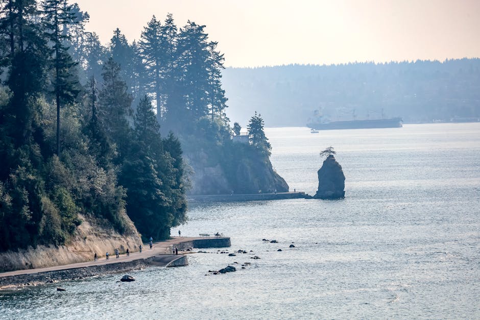Beautiful view of Stanley Park's coastal path with ocean and trees in Vancouver, BC, Canada.
