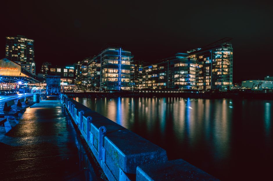 Stunning nighttime view of North Vancouver's illuminated waterfront with cityscape reflections.