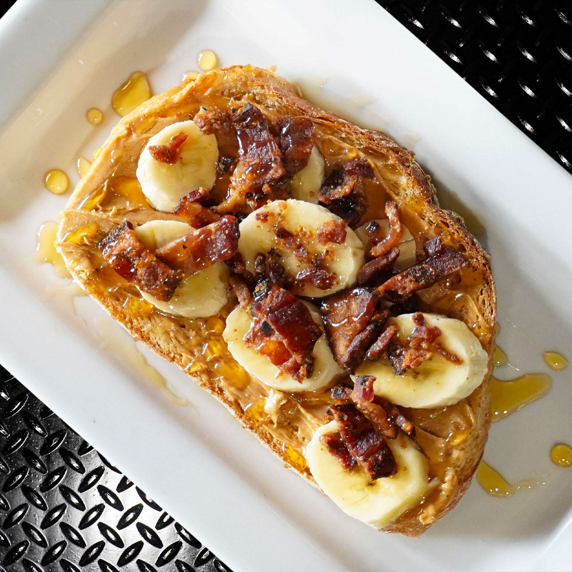 Peanut butter, sliced banana, three pepper candied bacon & a honey drizzle on toasted country white.