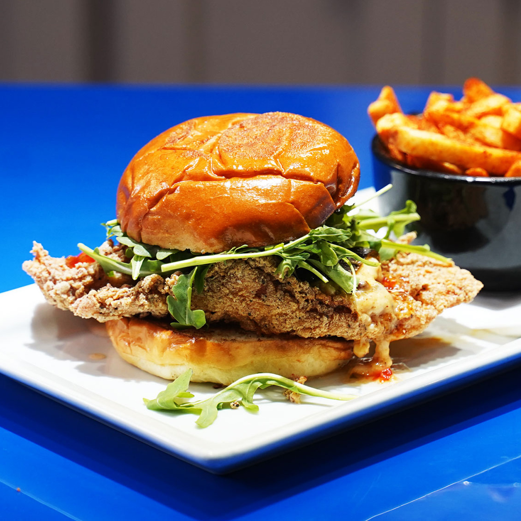 Southern fried chicken breast tossed in jalapeño jam and topped with a roasted poblano pepper stuffed with three cheese and roasted corn, arugula and spicy aioli