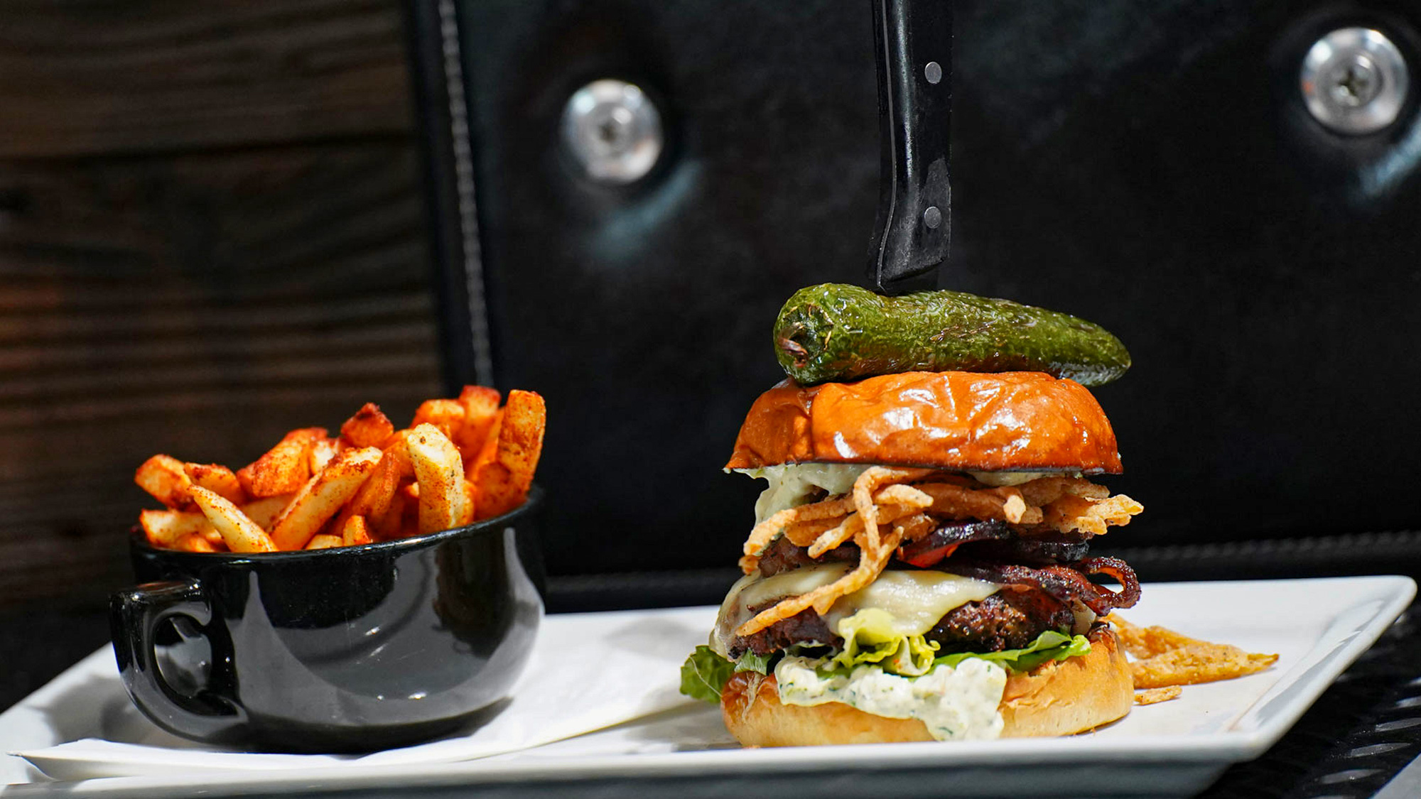 Premium smash patty topped with jack cheese truffled onion strings, pepper candled bacon, romaine hearts, roasted jalapeño, cream cheese spread and a whole fried jalapeño