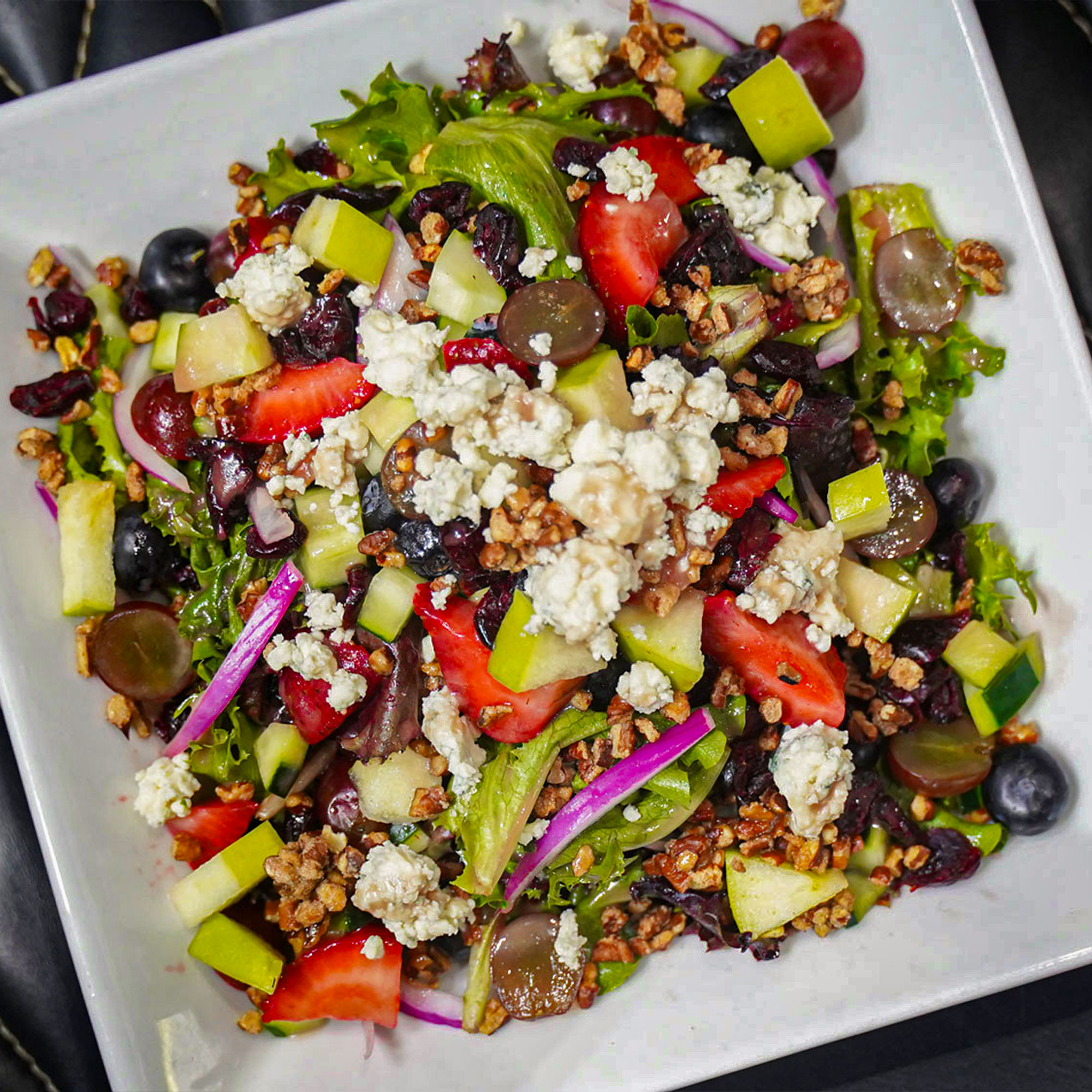 Mixed greens, blue cheese, strawberry, blueberry, dried cranberry, grapes, cucumber, apples, red onions and candied pecans with pomegranate vinaigrette.