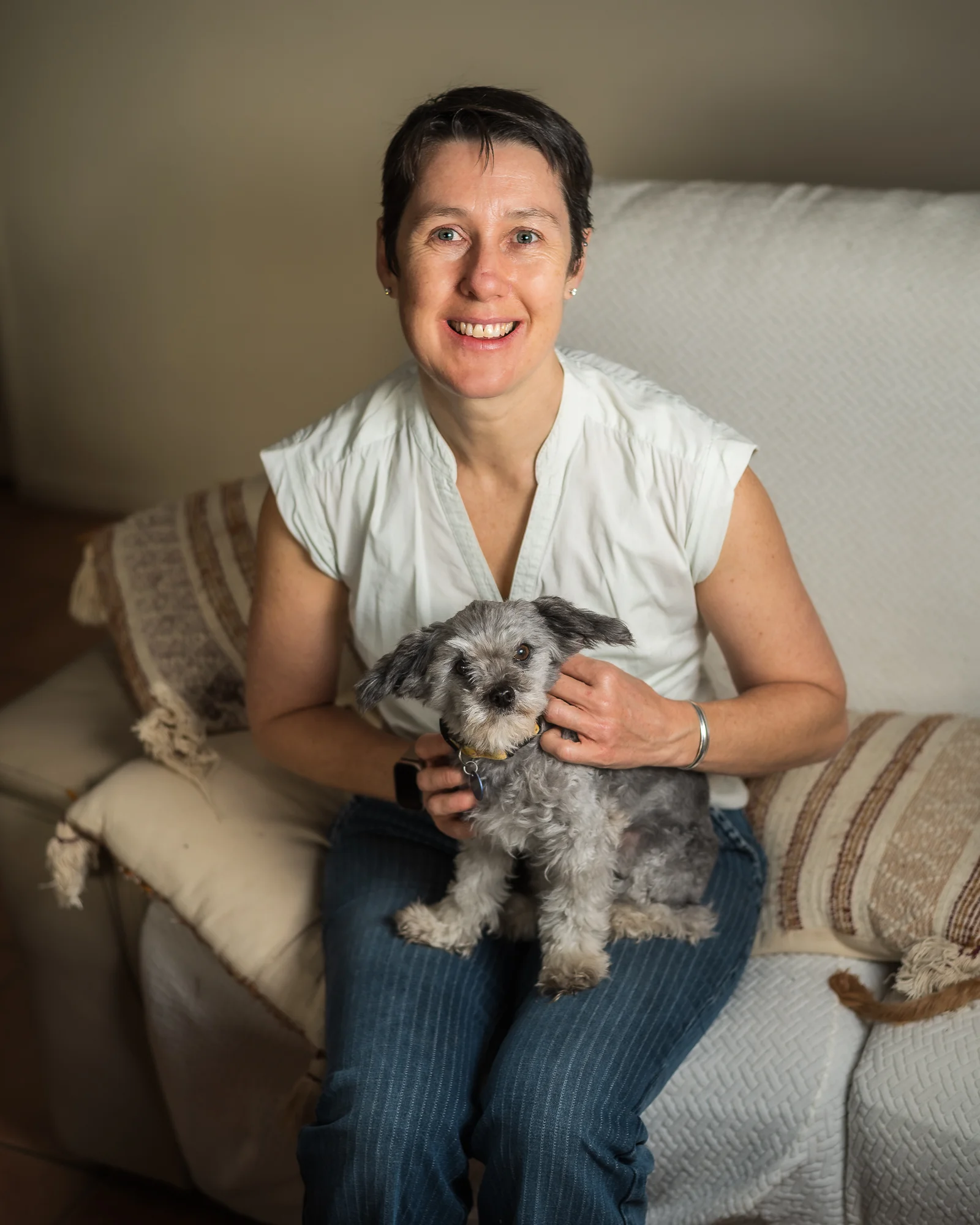 Cath sitting and smile with her dog